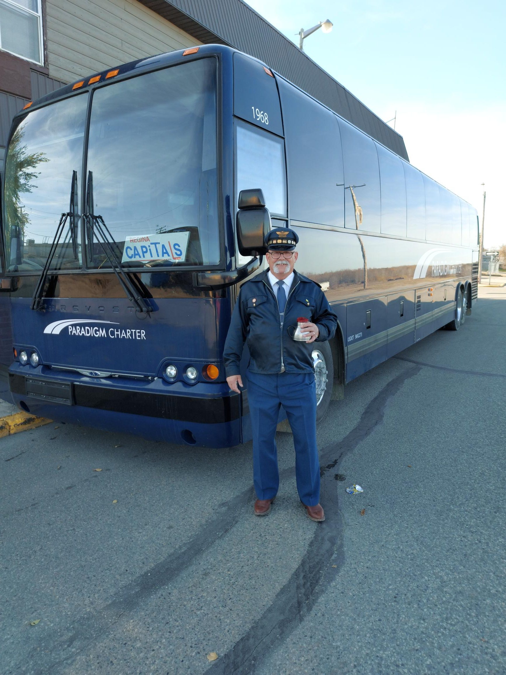 Professional driver at the wheel of a luxurious Paradigm Bus Charter in Saskatchewan, ensuring a safe and comfortable journey.